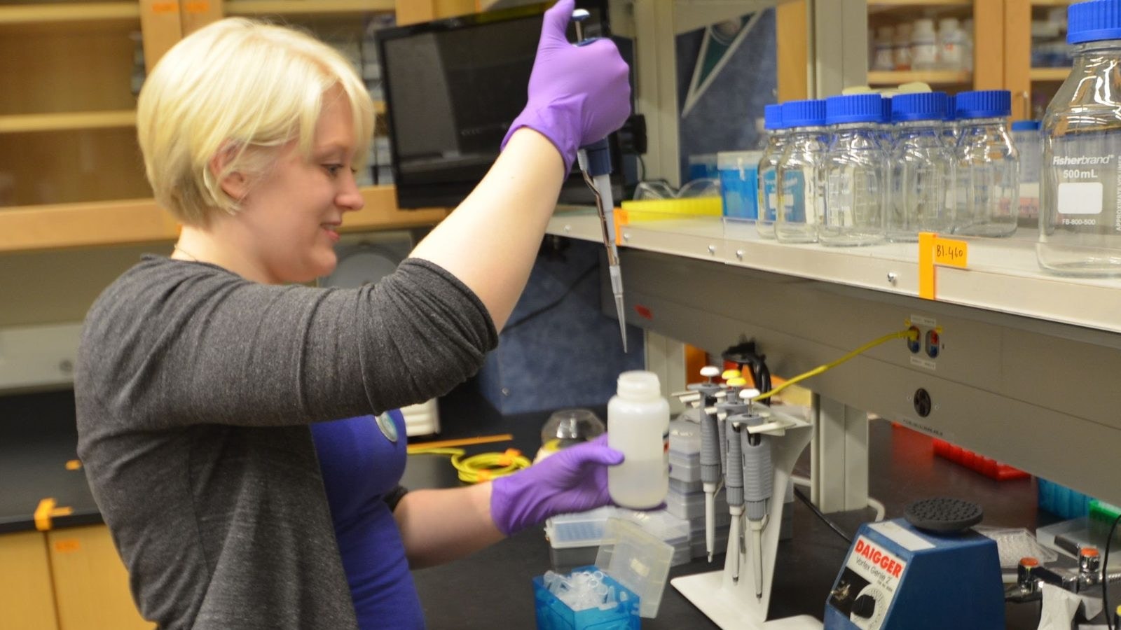 Researcher using a pipette at a wet laboratory bench