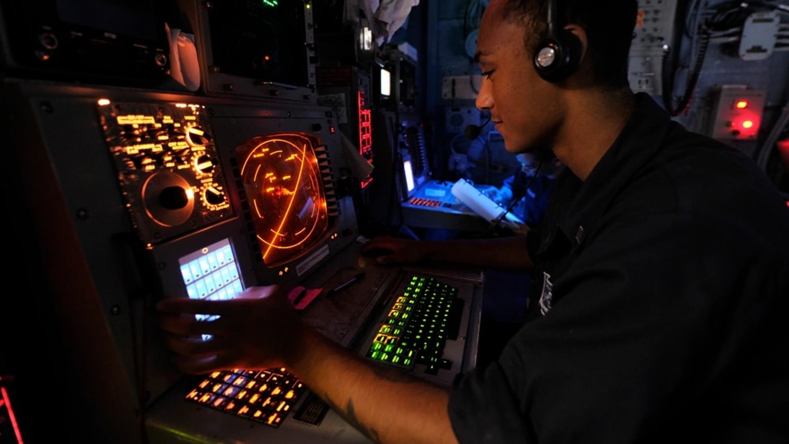 U.S. Navy operations specialist monitoring a radar console aboard USS Bataan