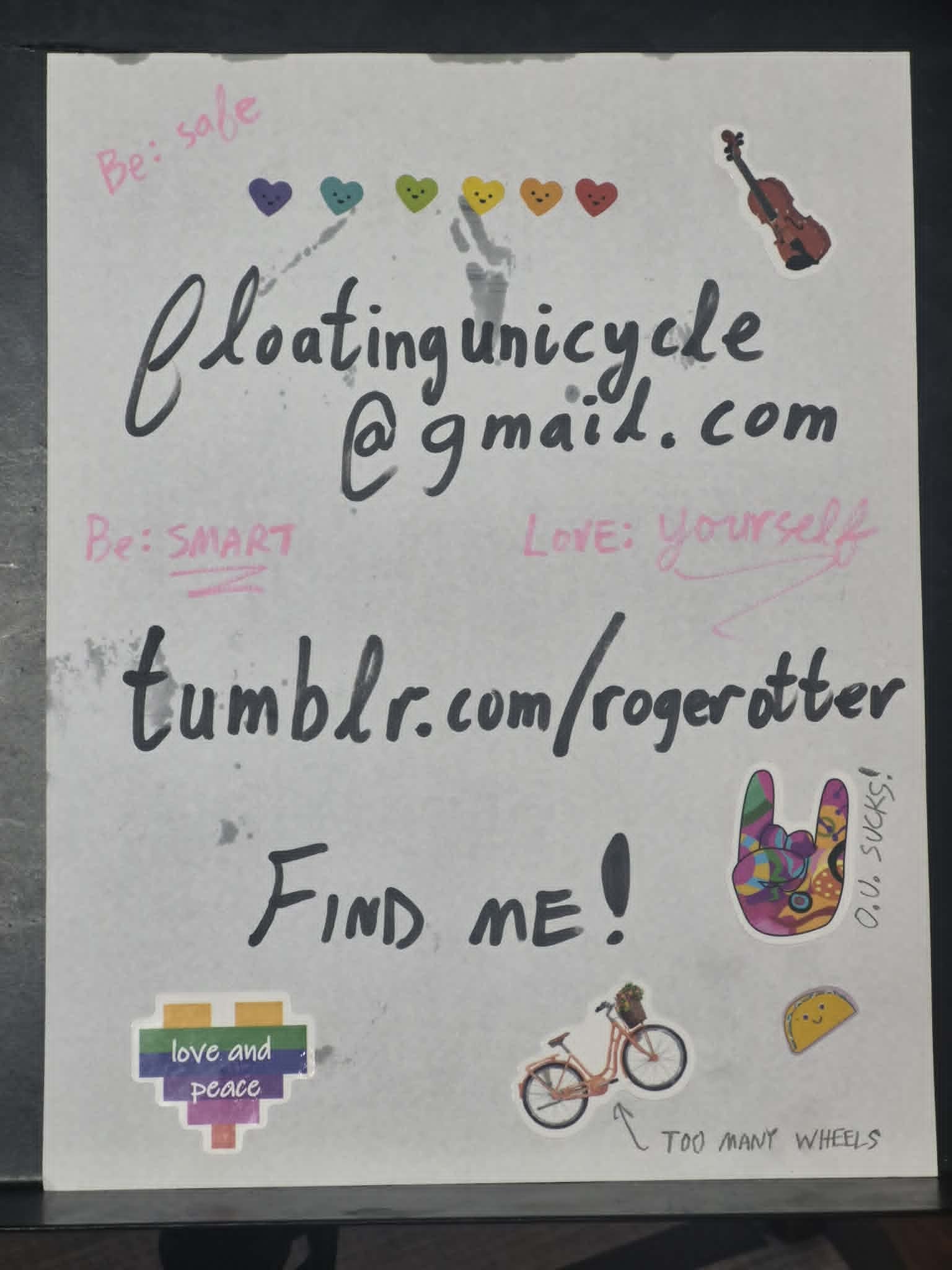 Handmade poster containing handwritten contact information, the phrase FIND ME, safety reminders, hearts, stickers, a violin, and a bicycle drawing
